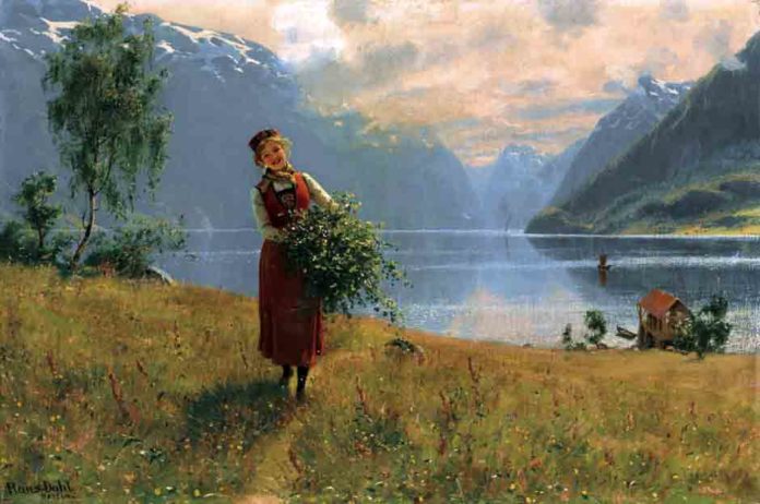 挪威峡湾前一个年轻的女孩,她拿着桦木树枝